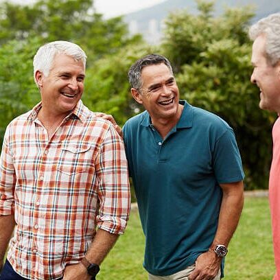 Happy mature male friends spending leisure time in park